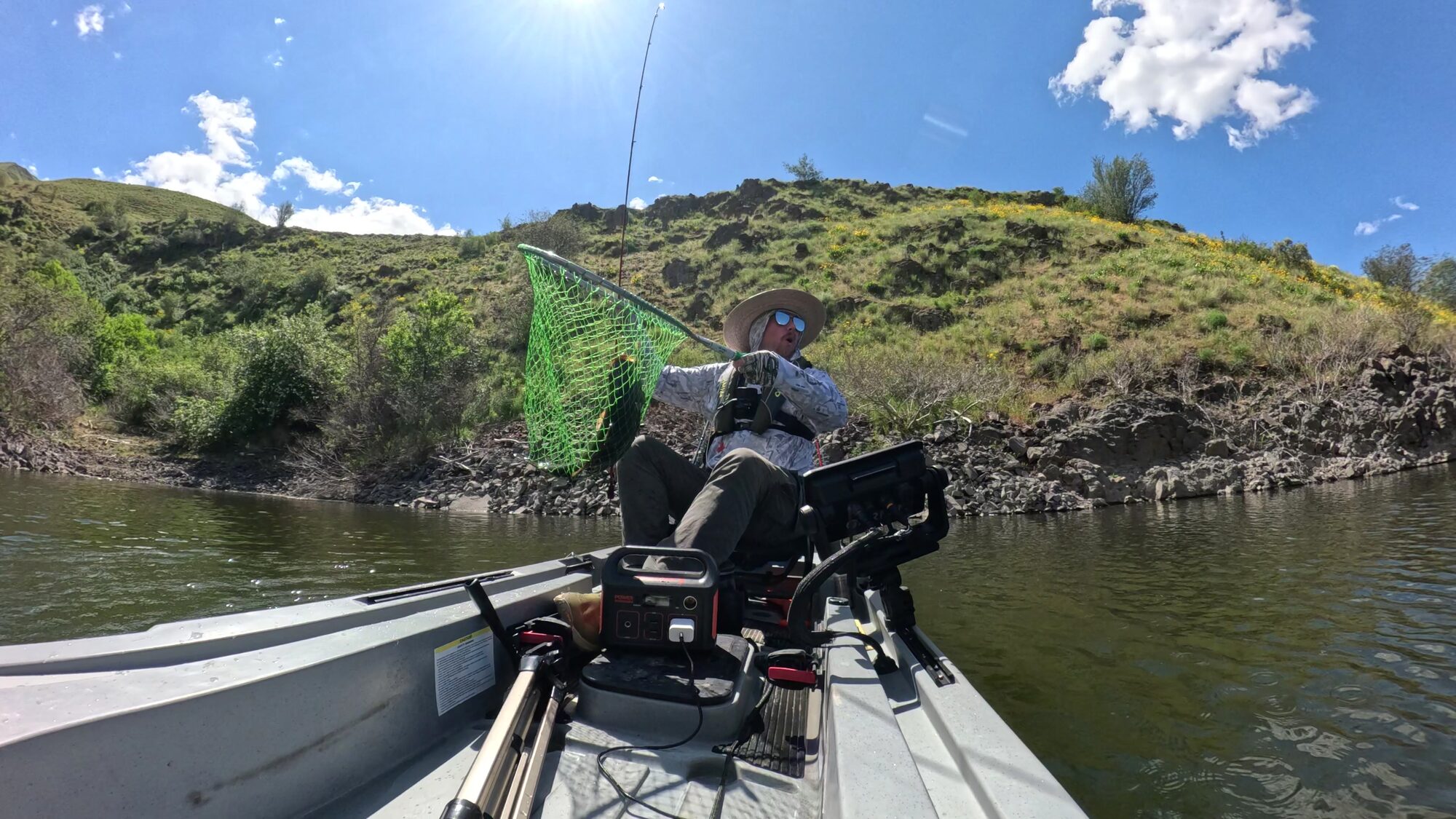 Zack lifting a personal best smallmouth in the net from his kayak on Brownlee Reservoir